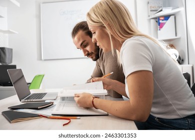Two language learning students are focused on taking a test in their language class, showcasing their dedication to mastering a foreign tongue.	