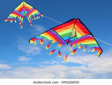 Two Large Colorful Kites Flying High In The Sky With Brightly Colored