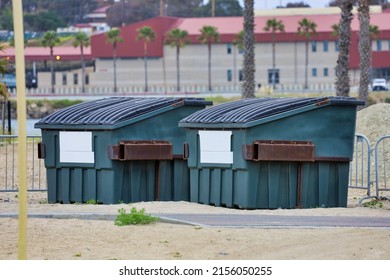 Two large commercial dumpsters for trash collection.