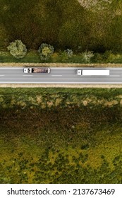 Two Large Freight Transporter Semi-trucks On The Road, Aerial View Top Down From Drone Pov