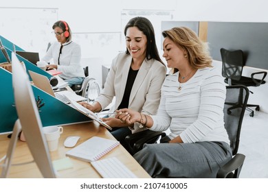 Two Latin Business Woman Middle Age, Talking And Advising Each Other At The Office In Mexico Latin America