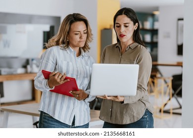 Two Latin Business Woman Middle Age, Talking And Advising Each Other At The Office In Mexico Latin America