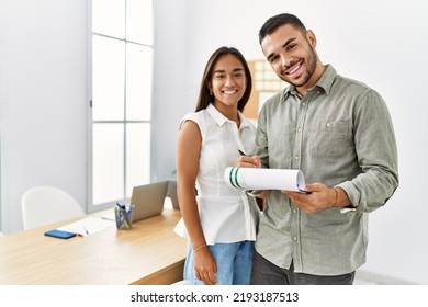 Two latin business workers smiling happy writng on clipboard working at the office. - Powered by Shutterstock