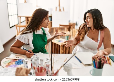 Two Latin Paint Students Arguing Sitting On The Table At Art School.