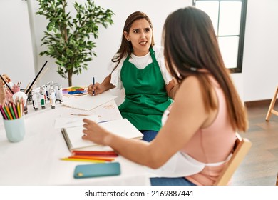 Two Latin Paint Students Arguing Sitting On The Table At Art School.