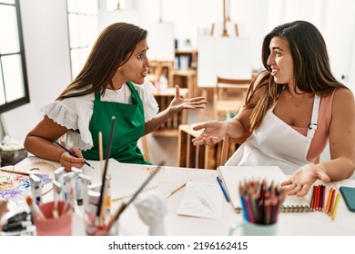 Two Latin Paint Students Arguing Sitting On The Table At Art School.