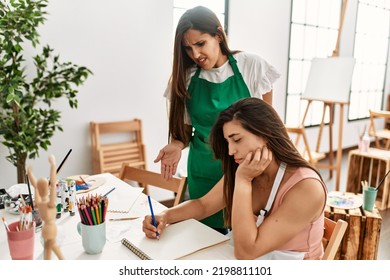 Two Latin Paint Students Arguing Sitting On The Table At Art School.