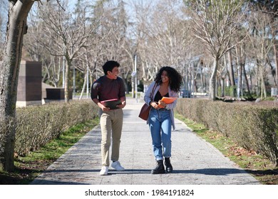 Two Latin Students Walking And Laughing At The College Campus. University Life.