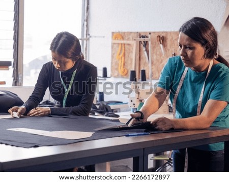Two Latin women working in a sewing workshop.