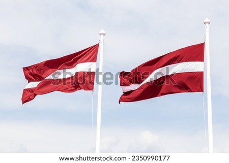 Two Latvian flags waving in the wind.
