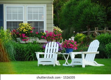 Two Lawn Chairs In A Beautiful Garden