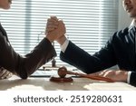 Two lawyers arm wrestling in a courtroom with a gavel on the table, symbolizing a legal battle and the pursuit of justice