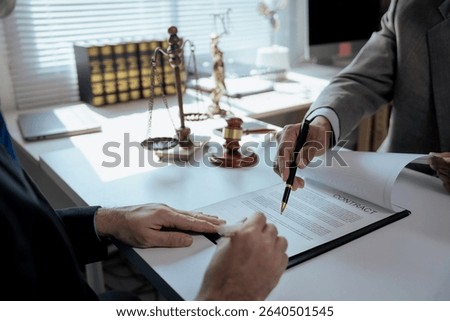 Two lawyers are discussing contract details with their client, ensuring a clear understanding before signing