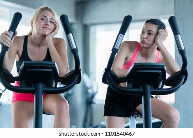 Two Lazy Caucasian  Girl Friend Bore And Tried To Workout On Stationary Bicycle In Gym