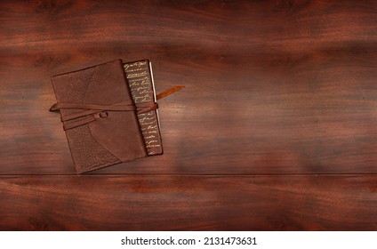 Two Leather Books Stacked On An Antique Wood Table With Copy Space On The Background