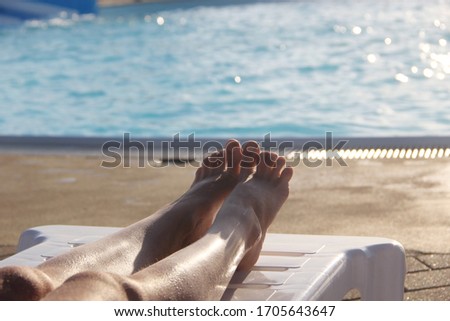 Two legs of a girl on the background of a pool in a water Park 