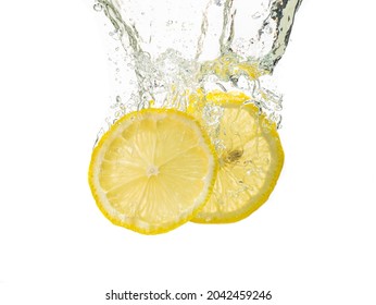 two lemon slices fall under the water with a splash
