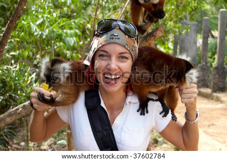 Two lemurs on the shoulders of a beautiful woman