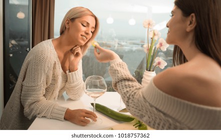 Two Lesbian Female Friends Making Salad In The Kitchen And Drinking Wine From A Wine Glasses. Life Stile Concept. Healthy Food