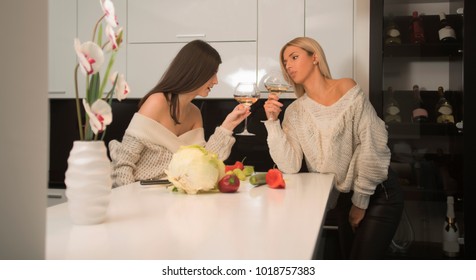 Two Lesbian Female Friends Making Salad In The Kitchen And Drinking Wine From A Wine Glasses. Life Stile Concept. Healthy Food