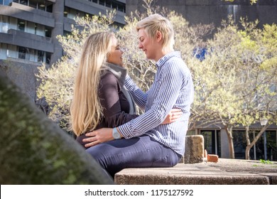 Two Lesbian Gay Women In Their Twenties Embrace Against A Black Wall In A City Landscape In Cape Town, South Africa