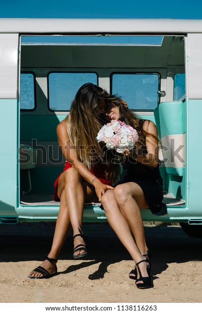 Two lesbian women\
kissing in the old van