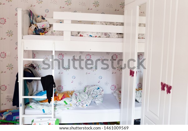 Two\
level bed with clothes everywhere, children\'s\
room