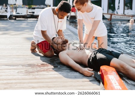 Two lifeguards performing cpr on unconscious man by the poolside, ensuring his safety and providing immediate medical assistance