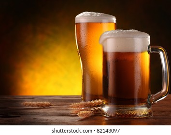 Two light beer glasses with barley spikelets on the dark yellow background. - Powered by Shutterstock