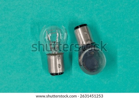 Two light bulbs replacement good new and old bad blown out element on blue background flat lay.