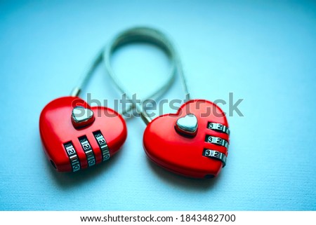 Two linked to each other in the form of the castle of hearts isolated on blue  background. Two love combination padlock bonded together. empty copy space for inscription. 14th february Valentines day.