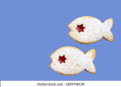 Two linzer cookies in a shape of fish isolated on blue background, copy space for text