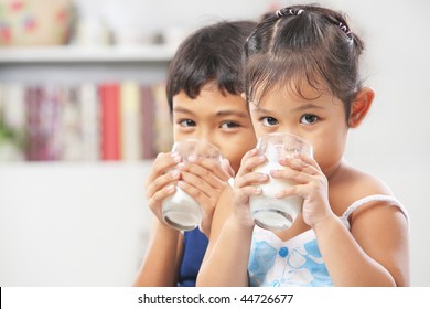 Hai cậu bé và cô gái uống sữa ở nhà