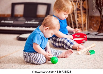 Two little boys enthusiastically playing with various musical instruments