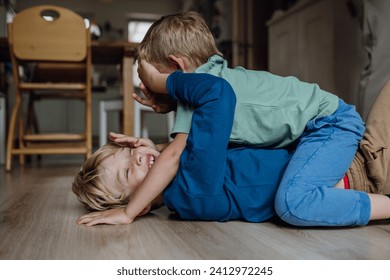 Two little boys fighting on the floor, brothers having fun at home. Concept of sibling relationship and brotherly love. - Powered by Shutterstock