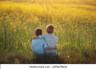 Two Little Boys Friends Holding Around The Shoulders In Sunny Summer Day. Brother Love. Concept Friendship. Back View.