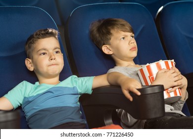 Two Little Boys Looking Annoyed And Bored Sitting At The Cinema Hall Watching Boring Movie Together Friends Friendship Unhappy Upset Disappointed Togetherness Kids Children Childhood Activity Concept 