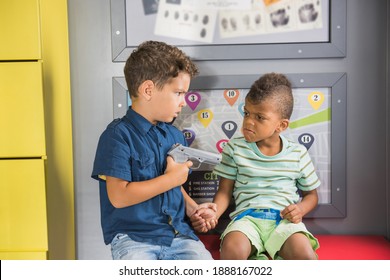 Two Little Boys Playing Police At Playground. Kid Policeman In Police Uniform Pointing Gun At Robber. Kids Leisure And Fun.