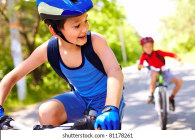 Two Little Boys Riding Bikes One After Another