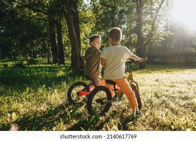 Two little boys riding their balance bikes in park. - Powered by Shutterstock