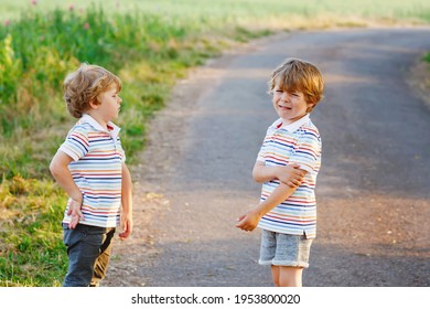 Two Little Brothers Boys Fighting. Twins, Upset Children Arguing Outdoors. Rivalry And Competition Betweens Siblings. Unhappy Twins. One Boy Crying.