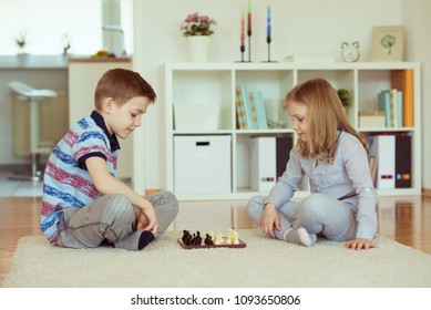Two little children playing chess at home  emotionally - Shutterstock ID 1093650806