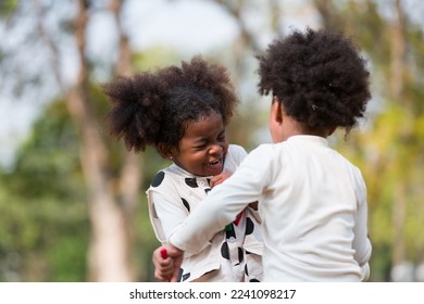 Two little children playing together outdoor in the park. Child girl and boy having fun outdoors. Black kid people enjoying outside - Powered by Shutterstock