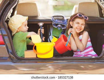 Two Little Children Sitting In Th Back Seat, Traveling On Summer Vacation.