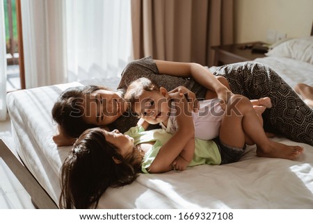 Similar – Top view of happy children having breakfast in the bed with their mother in a relaxed morning