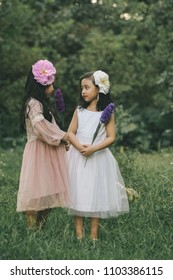 Two little girls in a beautiful dress in a park at sunset in Hanoi, Vietnam.