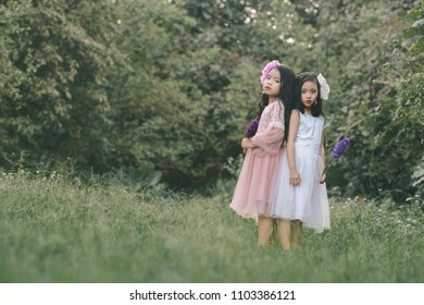 Two little girls in a beautiful dress in a park at sunset in Hanoi, Vietnam.