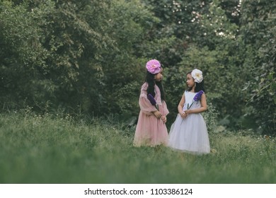 Two little girls in a beautiful dress in a park at sunset in Hanoi, Vietnam.