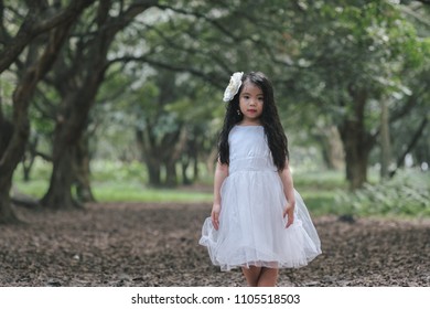 Two little girls in a beautiful dress in a park at sunset in Hanoi, Vietnam.