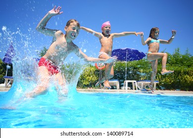 Two little girls and boy fun jumping into the swimming pool, shot through the underwater package. - Powered by Shutterstock